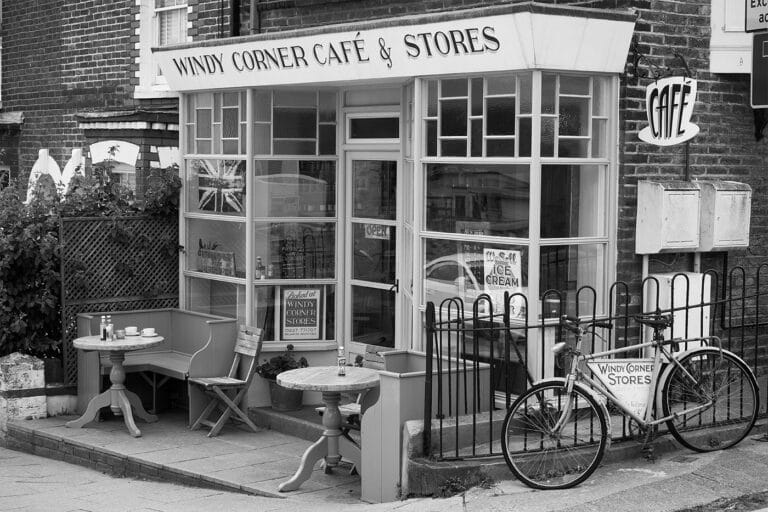 A small café with tables, chairs and a bicycle outside