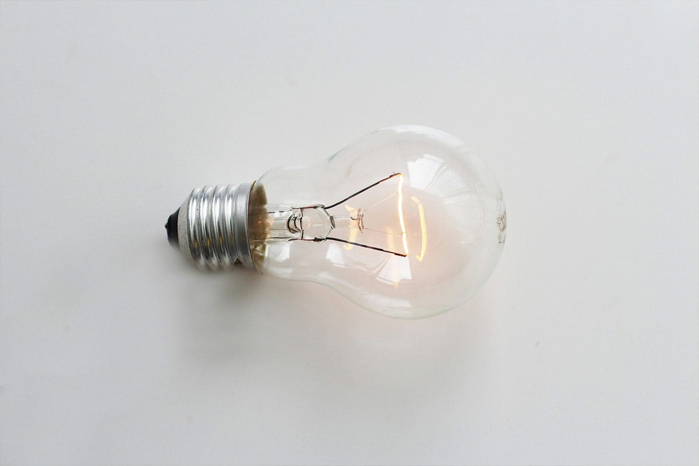A light bulb lit up, lying down horizontally on a surface
